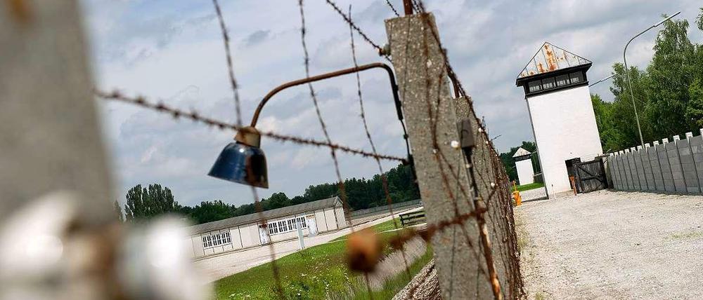 Ein Zaun und ein Wachturm an der Gedenkstätte des Konzentrationslagers Dachau.