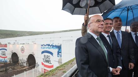 Der französische Premierminister Manuel Valls (Mitte) und Innenminister Bernard Cazeneuve (links) begutachten die Situation am Eurotunnel.