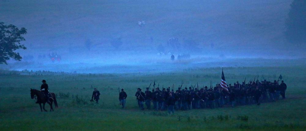 Nachstellungen historischer Ereignisse haben in den USA eine große Tradition. Zum Beginn der Feierlichkeiten zum 150. Jahrestag der Schlacht von Gettysburg in diesem Jahr stellten rund 10.000 Laienschauspieler den Schlachtverlauf nach. Das Bild zeigt, wie eine Gruppe "Unionssoldaten" am frühen Morgen das Schlachtfeld erreicht.