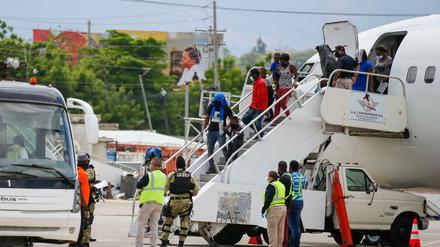 Haitianer, die aus den USA abgeschoben wurden, steigen am internationalen Flughafen Toussaint Louverture aus einem Flugzeug.
