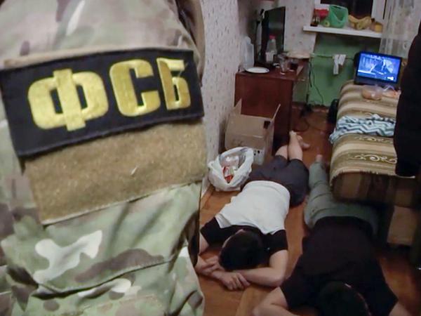 Dieses Bild veröffentliche der Geheimdienst FSB: Zu sehen sind Agenten, die zwei Männer festnehmen, die mutmaßlich Mitglieder der Terrormiliz Islamischer Staat sind. 