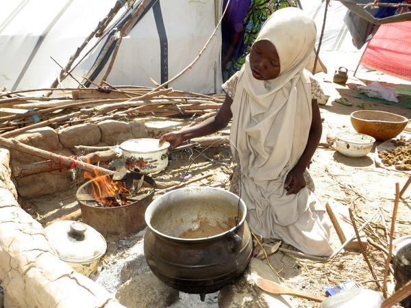 Ein Mädchen kocht in einem Flüchtlingslager in Maiduguri im Nordosten Nigerias. Die Flüchtlinge werden seit Monaten nur unzureichend versorgt. 