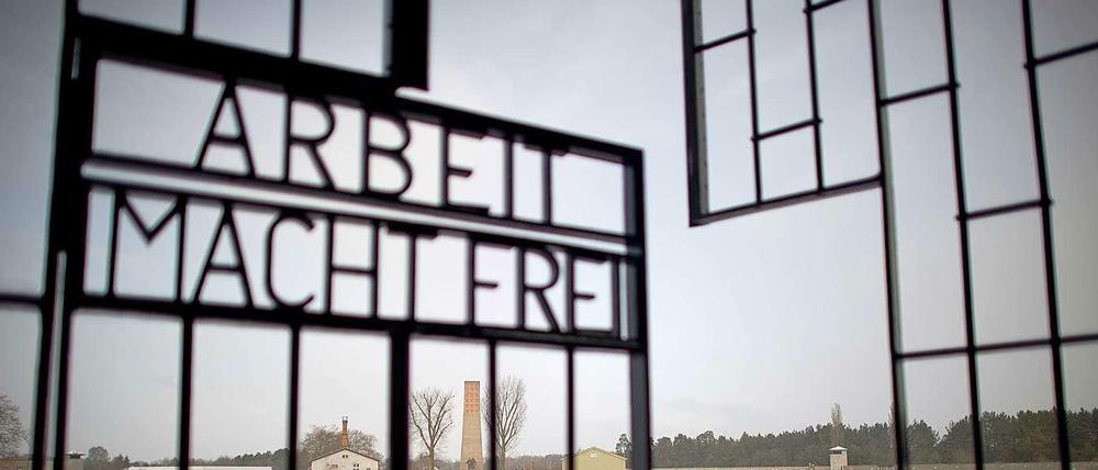 Das eiserne Tor eines Konzentrationslagers, welches die Worte "Arbeit macht frei" trägt.