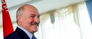 Alexander Lukaschenko, Präsident von Weißrussland, lacht bei der Stimmenabgabe in einem Wahllokal.