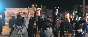 Protestierende Frauen ohne das vorgeschriebene Kopftuch heben ihre Hände und zeigen das Victory-Zeichen. (Archivbild)