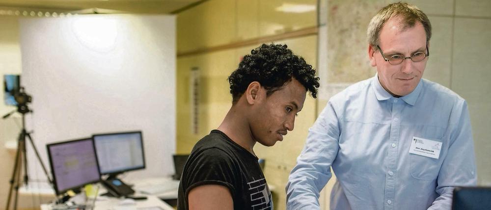 Die Fingerabdrücke des Flüchtlings Filimon, der nach eigenen Angaben aus Eritrea kommt, werden in der Erstaufnahmestelle in Suhl (Thüringen) von Sachbearbeiter Jörg Kenschik mit einem Scanner registriert.