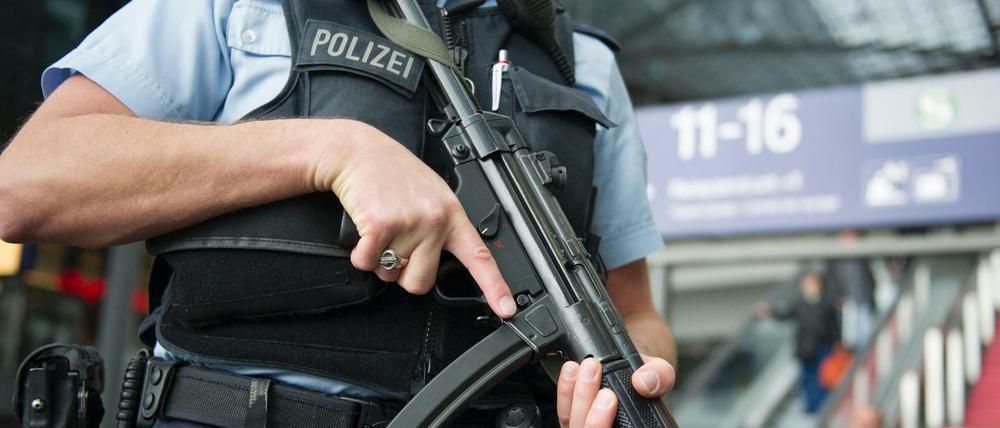 Ein Bundespolizist steht am 22.03.2016 in Berlin mit einer Waffe im Anschlag im Foyer des Hauptbahnhofs. 
