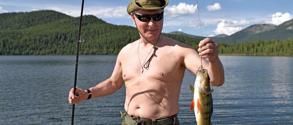 Russlands Präsident Wladimir Putin präsentiert einen Fisch.