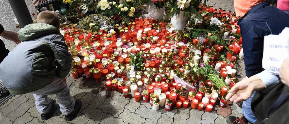 Kerzen und Blumen werden zum Gedenken an das 15-jährige Opfer am Drogeriemarkt in Kandel abgelegt.