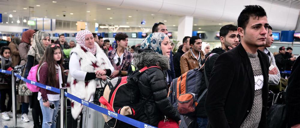 Flüchtlinge – die meisten aus Syrien – warten in Athen auf den Check-in für einen Flug in einen EU-Staat.
