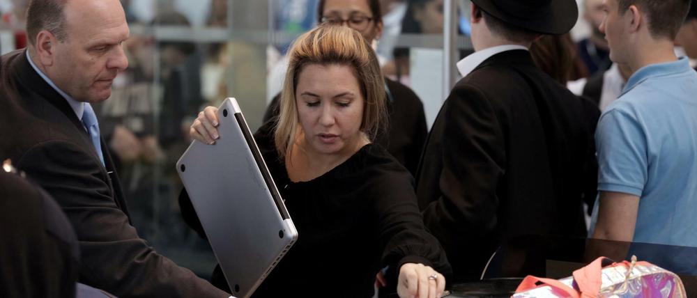 Eine Frau legt bei der Sicherheitskontrolle am Flughafen in den USA ihren Laptop in eine Kiste. Die USA erwägt, größere elektronische Geräte auf Flügen künftig komplett zu verbieten.