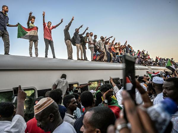 Sudanesische Demonstranten schwenken Nationalflaggen auf einem Zug am 23. April 2019 in Khartum, Sudan. 