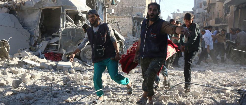Freiwillige bergen nach den Luftangriffen vom Samstag im von Rebellen gehaltenen Stadtteil Heluk eine verletzte Person.