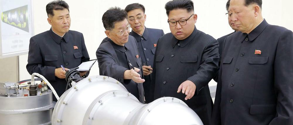 Kim Jong Un (4. v. l.) lässt sich - nach nordkoreanischer Darstellung - den Sprengkopf einer Wasserstoffbombe zeigen.