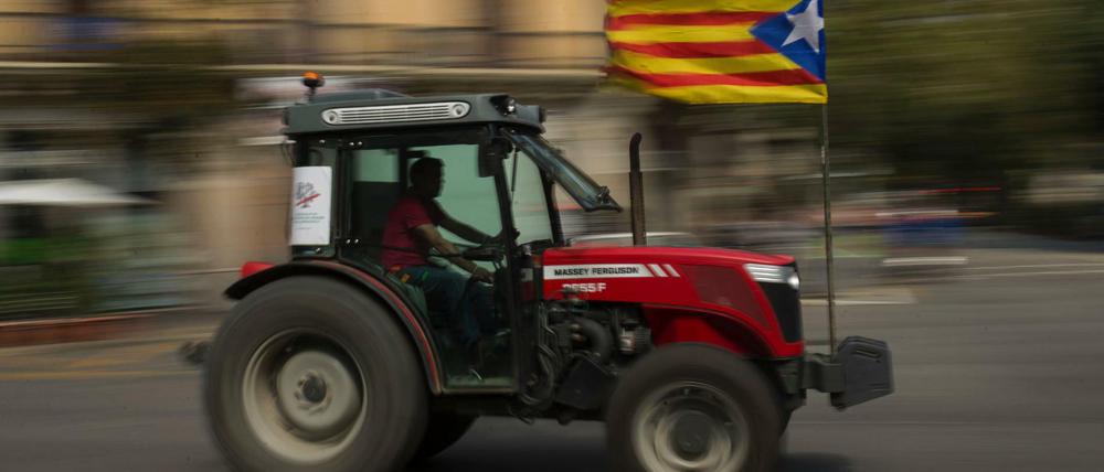 Motorisierte Meinungsäußerung. Ein Mann fährt in Barcelona mit der katalonischen Fahne an seinem Traktor. 