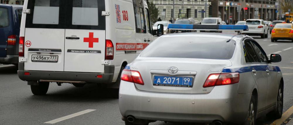 Ein Krankenwagen fährt in Moskau an einem Polizeiauto vorbei, das vor der Radiostation des Senders Ekho Moskvy parkt. 