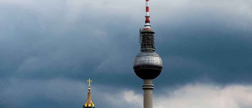 Eine der vielen Ideen, wie das Klima künstlich beeinflusst werden könnte, ist die technische Aufhellung von Wolken, damit mehr Sonnenlicht in den Weltraum abgestrahlt wird und die Erdoberfläche gar nicht erst erreichen kann. Das Foto zeigt den Berliner Fernsehturm und die Spitze der Marienkirche vor dunklen Regenwolken. 