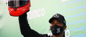 Roter Helm, schwarzes Outfit. Lewis Hamilton bei der Siegerehrung.
