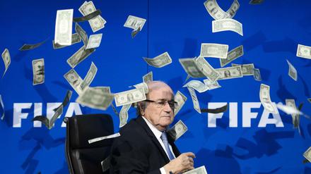 Ungewollter Geldregen. Joseph Blatter wird von einem Komiker mit Dollarnoten beworfen.