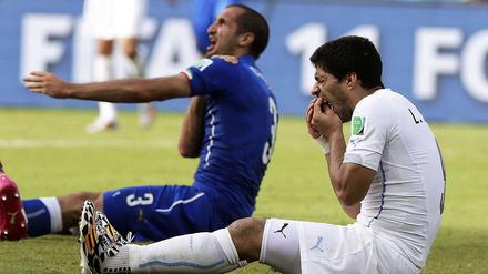 Szene der WM. Luis Suarez (r.) hält sich die Zähne, Giorgio Chiellini die Schulter.