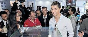 Schuhtick. Cristiano Ronaldo stellt sich während der Museumseröffnung 2013 neben einen seiner zwei Goldenen Schuhe, die er als weltbester Torschütze bekommen hat.