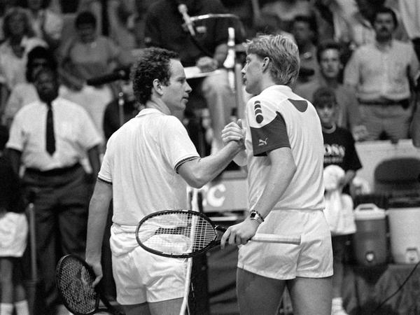 Handschlag. Boris Becker (r) und John McEnroe geben sich nach ihrem Match im Civic Center die Hände. Ihr Duell ging als eines der längsten Spiele in die Geschichte des Daviscup ein. 