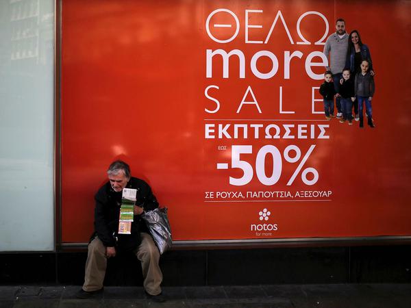 Ein Lotto-Rubbellosverkäufer sitzt vor einem Einkaufszentrum in Athen (aufgenommen am 18. Februar 2017).