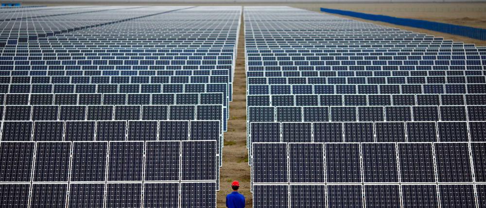 Ein Arbeiter inspiziert eine Photovoltaikanlage in Dunhuang in der Provinz Gansu. China investiert massiv in erneuerbare Energien.