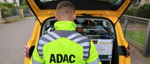 Ein ADAC-Pannenhelfer steht nach einer Pannenhilfe am Kofferraum seines Fahrzeugs (Symbolbild).