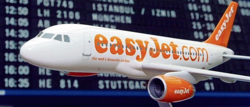 Ein Flugzeugmodell der britischen Billig-Airline easyJet steht vor der Anzeigetafel. 