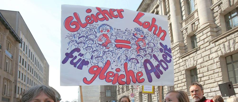 Berlins Lehrer streiken für bessere Arbeitsbedingungen. Zwei Frauen halten ein Schild in der Hand mit der Aufschrift "Gleicher Lohn für gleiche Arbeit."
