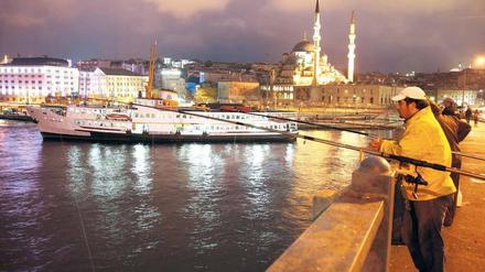 Volkssport in Istanbul. Angeln im Bosporus von der Galatabrücke aus, die das Goldene Horn überspannt. 
