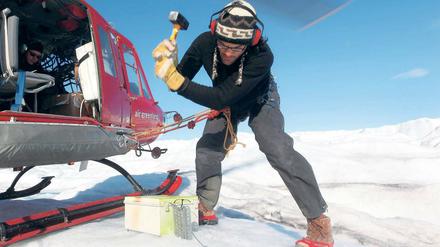 Präzisionsarbeit. Ein Glaziologe platziert eine GPS-Station auf dem grönländischen Eis, die unter anderem seismische Wellen erfasst. Mit diesen Geräten soll die Fließbewegung des Eispanzers verfolgt werden. 
