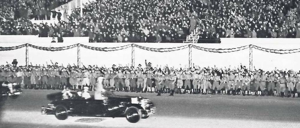Hitler fährt anlässlich seines 50. Geburtstages im Jahr 1939 an der TH Berlin vorbei, auf einer Tribüne zeigen Hunderte den Hitlergruß
