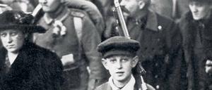 Ein Junge bringt am 1. August 1914 den Koffer und das Gewehr seines Vaters zum Bahnhof.