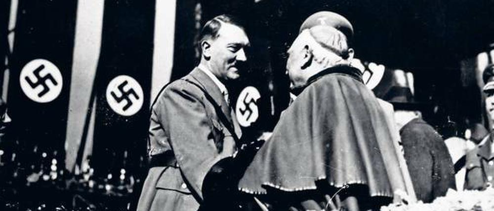 Das Bild zeigt Hitler beim Händeschütteln mit einem katholischen Bischof.