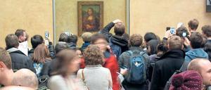 Besuchermassen stehen im Louvre vor dem Bildnis der Mona Lisa.