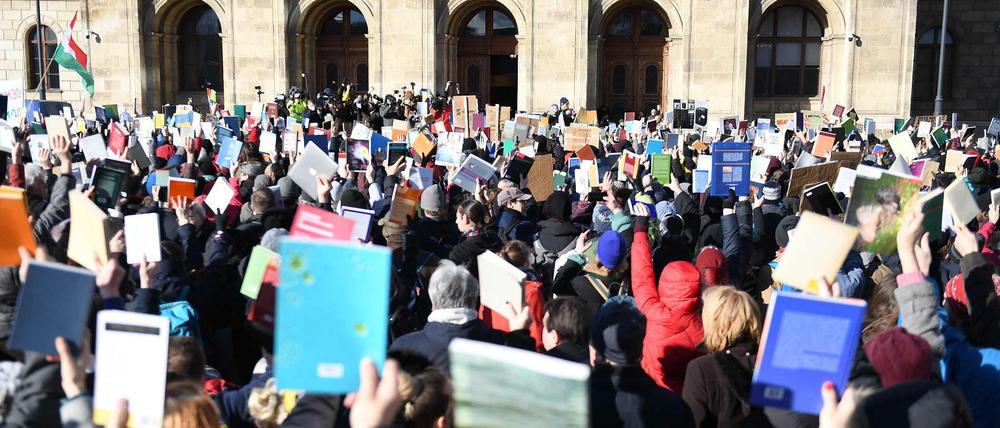 Proteste gegen die Wissenschaftspolitik vor der Akademie der Wissenschaften in Ungarn. Die Demonstranten halten Bücher hoch.