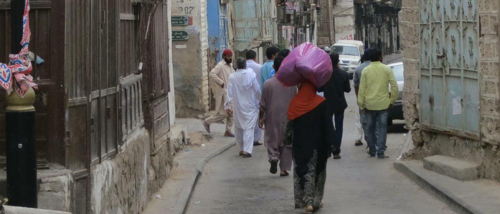 Eine Gruppe von Männern geht durch eine Gasse in der Altstadt von Jidda.