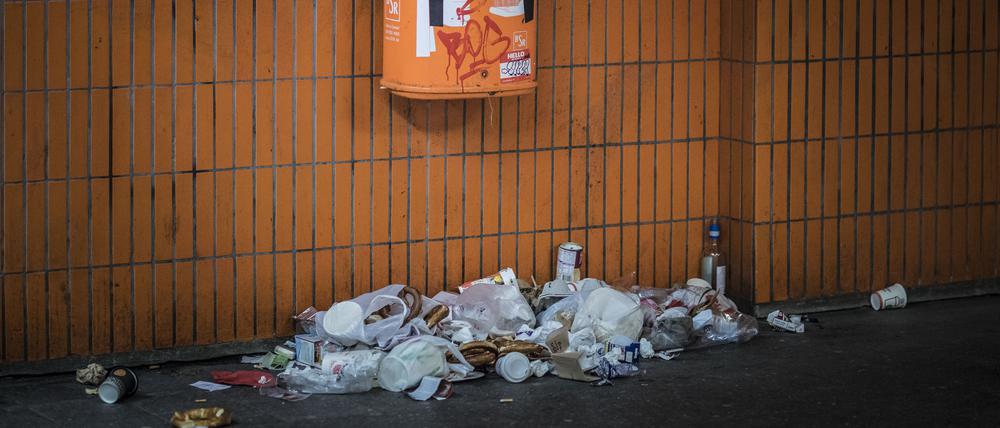 Müll liegt unter einem Mülleimer in Berlin.