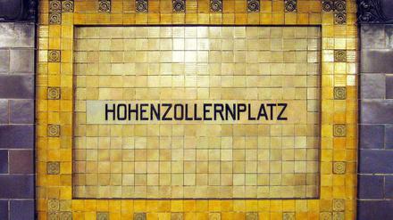Historisches Stationsschild in den Farben gelb und violett im U-Bahnhof Hohenzollernplatz.