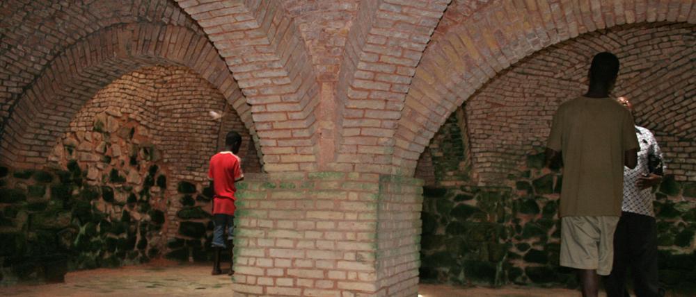Besucher in Rückenansicht im "Slave Dungeon" im historischen Fort Groß Friedrichsburg im heutigen Ghana.