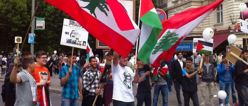 Libanesische und palästinensische Flaggen sowie das Konterfei des iranischen Revolutionsführers: Israelfeinde am Adenauerplatz zu Beginn der Demonstration.