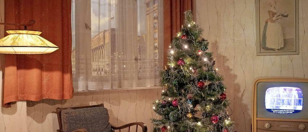 Aluminium-Lametta glitzert. Weihnachtsatmosphäre im DDR-Musterzimmer der "Story of Berlin". Über dem Schwarz-Weiß-Fernseher hängt ein Bild des Scholadenmädchens.