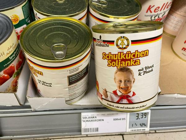 "Schulküchen-Soljanka" mit Staatswappen der DDR im Konservenregal eines Rewe-Markts.