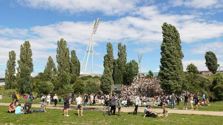Menschen haben sich an einem Sommertag im Mauerpark versammelt. 