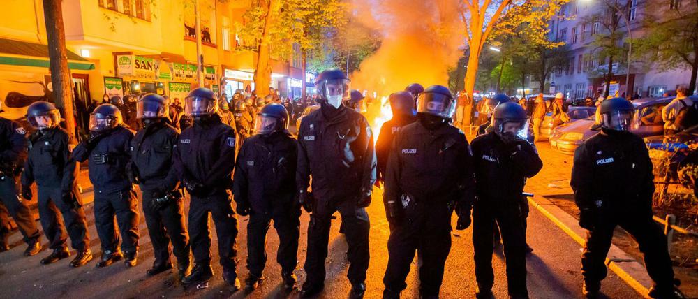 Polizisten stehen am 1. Mai 2021 vor einem Feuer am Rande der "Demonstration zum revolutionären 1. Mai".