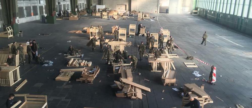 Bundeswehr, Feuerwehr und freiwillige Helfer bauen am Freitagnachmittag gemeinsam Betten im Hangar 3 des Flughafens Tempelhof auf.