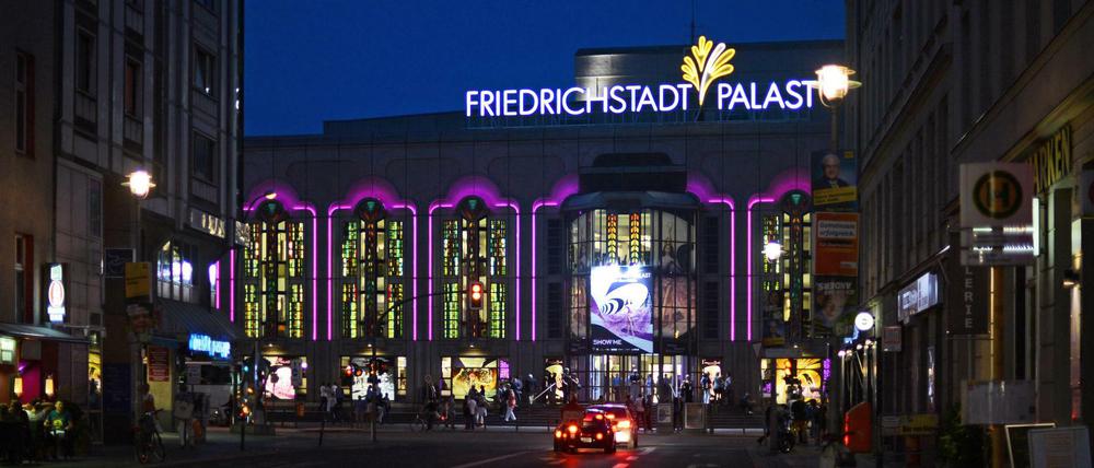 Der Friedrichstadtpalast in der Friedrichstraße ist am 22.08.2013 in Berlin Mitte am Abend stimmungsvoll beleuchtet. Die Beleuchtung spiegelt sich in einem Autodach.