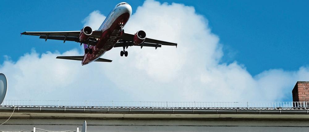 Ein Flugzeug nähert sich über einem Wohngebiet dem Flughafen Tegel. 